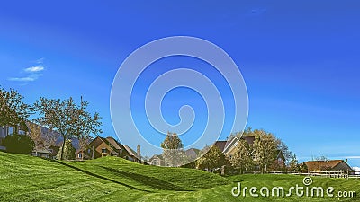 Panorama Narrow paved road on a vast grassy terrain under blue sky on a sunny day Stock Photo