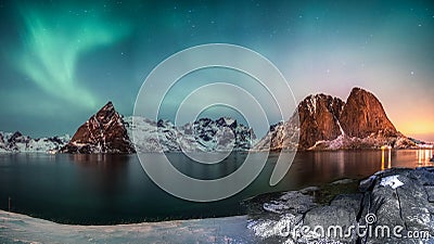 Panorama of Northern lights over mountain in hamnoy fishing village in winter Stock Photo