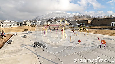 Panorama Park and childrens playground against homes and snow capped mountain in winter Stock Photo