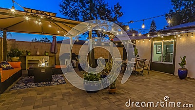 Panorama Patio of home with seating area under a gazebo and dining area under an umbrella Stock Photo