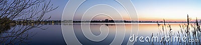 A panorama photo during the Blue hour on a allmost windless evening with a smooth lake Zoetermeerse Plas, Netherlands Stock Photo