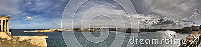 Panorama photo of the Valletta city Grand harbor area at Malta,many historic buildings along coastline and Siege Bell Memorial Stock Photo