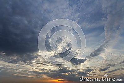 Panorama of sky at sunrise or sunset. Beautiful view of dark blue clouds lit by bright orange yellow sun on clear sky. Beauty and Stock Photo