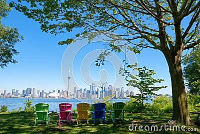 Panorama of Toronto, Canada over chairs different colours and tree from Isand on sunny day Editorial Stock Photo