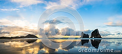 Panorama view. The beautiful Wharariki Beach with famous rocks. Sunset scene golden light and silhouette. Nelson, South Island, Stock Photo