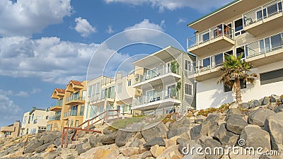 Panorama White puffy clouds Beachfront houses with view decks and glass railings at Oceansid Stock Photo