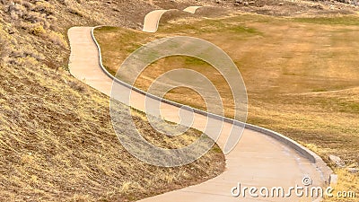 Panorama Winding narrow rural road through foothills and grass Stock Photo