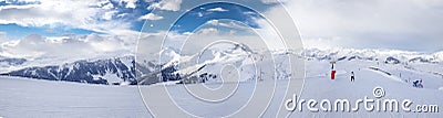Panoramaview to ski slopes and skiers skiing in Kitzbuehel mountain ski resort with a background to Alps in Austria Stock Photo