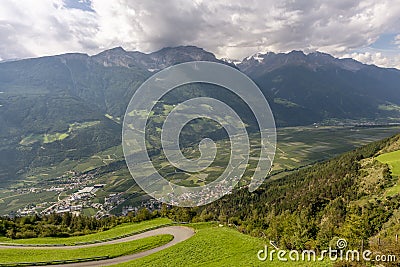 Panoramic aerial view of the hairpin bends that ascend Monte di Silandro, with Corzes in the background, Val Venosta, Italy Stock Photo