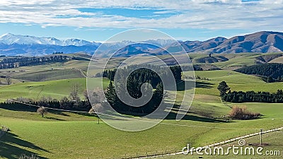 Panoramic views of mountain ranges and rolling hills and valleys covered in lush green rural agricultural farming crop Stock Photo