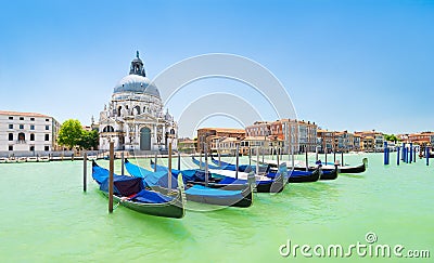 Panoramic view of traditional venetian gondolas moored in water of Grand Canal in front of Basilica di Santa Maria della Salute Stock Photo