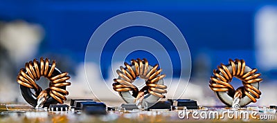 Panoramic electrotechnical background. Toroidal inductors with beautiful copper wire winding Stock Photo