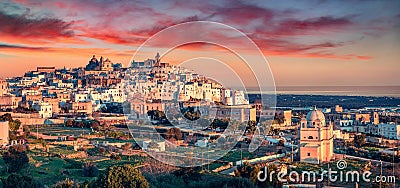 Panoramic evening cityscape of Ostuni town. Majestic summer sunset on Apulia, Italy, Europe. Stock Photo