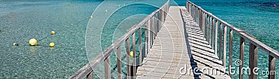 Panoramic image diminishing perspective wooden boardwalk empty path through turquoise Mediterranean Sea Stock Photo