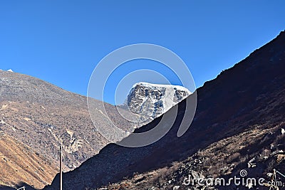 Panoramic landscape view of barren Himalayas mountain range with distant snowcapped great Himalayas mountain on a winter day in Stock Photo