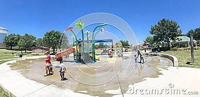 Panoramic multicultural kids and parent playing at splash park in Texas in post COVID-19 pandemic Editorial Stock Photo
