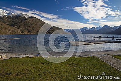 Panoramic peaceful picturesque landscape country side scenic view lake waterfront jetty wooden pier on lake water with Alps Stock Photo