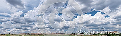 Panoramic picture of small town and stunning skyscape with cumulus clouds Stock Photo