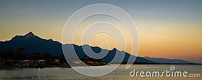 Panoramic shot of buildings near the sea with mountains in the background in Atlantida Honduras Stock Photo