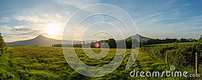 Panoramic shot of farmland with overlook to mountains during a sunny day Stock Photo
