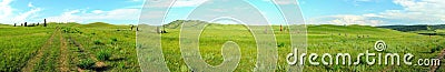 Panoramic shot of a hilly steppe with a field road and ancient stone menhirs Stock Photo