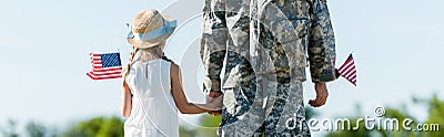 Shot of patriotic child and man in military uniform holding hands and american flags Stock Photo