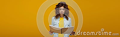 Shot of upset redhead young woman looking at notebook and holding pen on orange Stock Photo