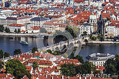 Panoramic view from above of Prague, Charles bridge with crowds of tourists, the Vltava river and red roofs. Stock Photo