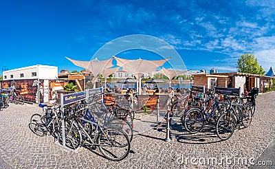 Panoramic view of a beach bar and cafeteria at Elbe river bank with many bicycles in front outdoor in Magdeburg downtown, Eastern Editorial Stock Photo