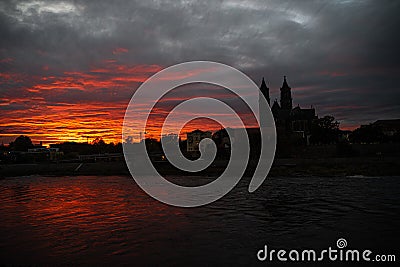 Panoramic view of beautiful bloody sunset in front of Cathedral of Magdeburg, downtown and river Elbe, Magdeburg, Germany, Autumn Stock Photo