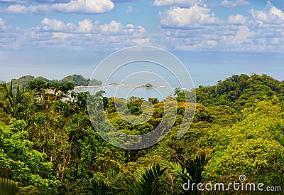 A panoramic view of Dominical Beach in Costa Rica on a mostly sunny day with some puffy white clouds in Central America. Stock Photo