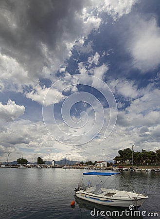 Panoramic view of Fishing boat on a sunny afternoon on the calm Aegean Sea on the waterfront of the seaside town of Nea Artaki on Editorial Stock Photo