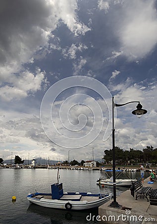 Panoramic view of Fishing boat on a sunny afternoon on the calm Aegean Sea on the waterfront of the seaside town of Nea Artaki on Editorial Stock Photo