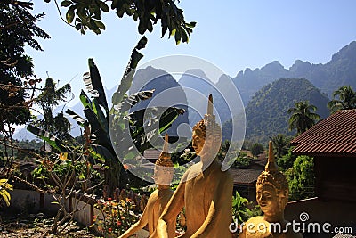 Panoramic view on karst hill landscape with golden buddha statues from a temple Stock Photo