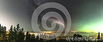 Panoramic view of Northern Lights and atmospheric phenomenon `STEVE` meets Milky Way. Steve appears as a purple and green light Stock Photo