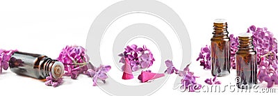 oil essential bottle and pink petals of lilac flowers on white Stock Photo