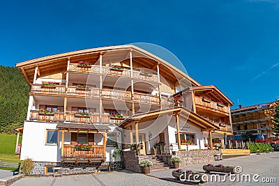 Panoramic view over magical Dolomite peaks, forests and hotels at sunny day and blue sky, Colfosco, Corvara, at Puez-Geisler, Puez Editorial Stock Photo