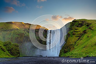 Panoramic view of the Skogafoss waterfall in Iceland. In the morning, the sunrise from behind a mountain Stock Photo