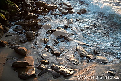 Panoramic view of sunset over ocean. Sea waves lash line impact rock on the beach. Stock Photo