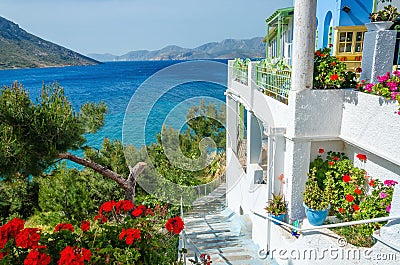 Panoramic view on typical Greek studio with flowers and white te Stock Photo