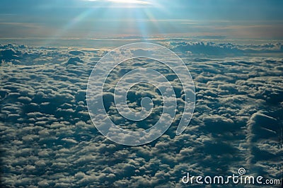 Panoramic view from the window of the plane flying above the sun-drenched clouds Stock Photo