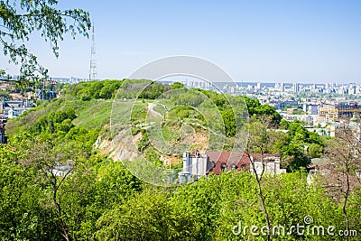 Panoramic view of the Zamkova Hora Castle Hill or mount in Kyiv covered with greenery. In the background cityscape of Podil and Stock Photo