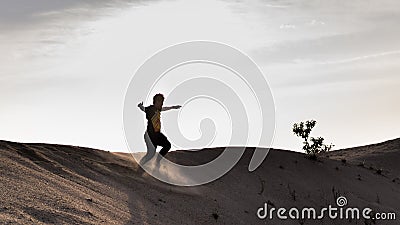 A black and white silhouette view of a young man running freely at the center of desert with sunset as background at Klebang Beach Editorial Stock Photo