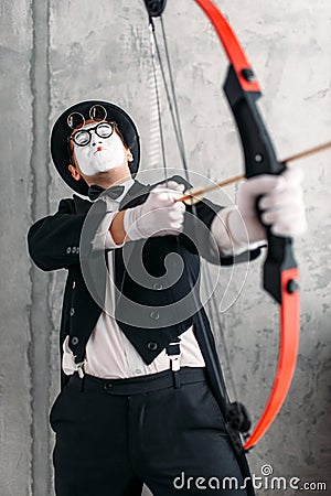 Pantomime actor performing with sports bow Stock Photo