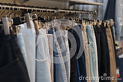 Pants and jeans on the racks in clothing store Stock Photo