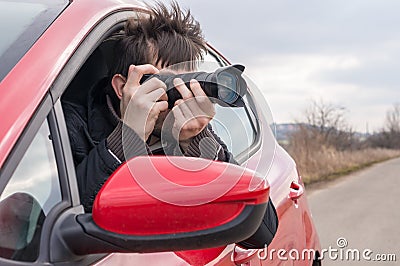 Paparazzi is taking photo with camera from car Stock Photo