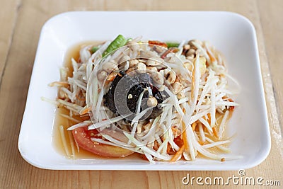 Papaya salad with preserved crab with salt or Thai people call Som Tam Poo in white plate is a famous food. Stock Photo