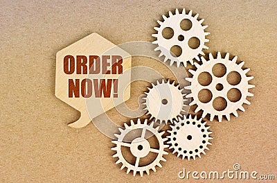 On a paper background, gears and a thought plate with the inscription - Order Now Stock Photo