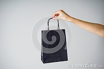 Paper blue craft bag, eco packaging in a female hand, on a gray background Stock Photo