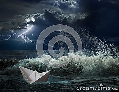 Paper boat in ocean storm with lgihting and waves Stock Photo